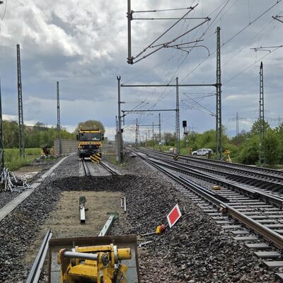 Eine Gleisbaustelle im Hintergrund steht ein Kipplaster auf den Gleisen.