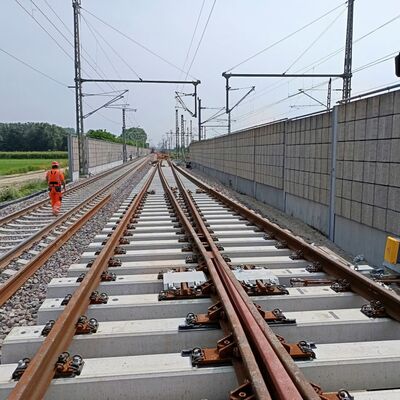 Eine Person läuft neben neuen Gleisen entlang.